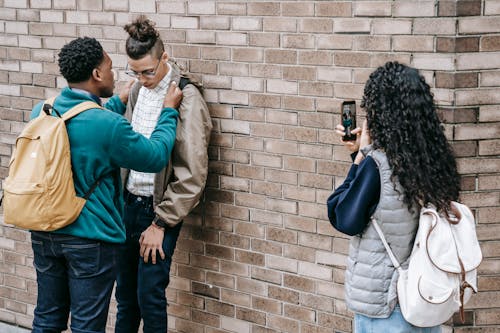 Femme filmant deux hommes avec son téléphone