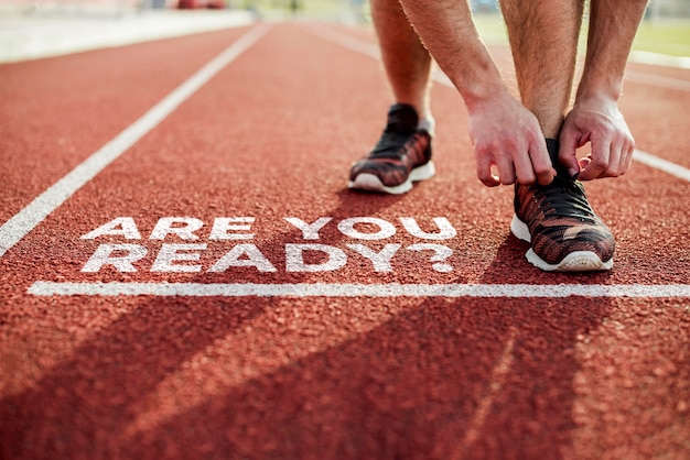 Athlète sur une piste d'athlétisme avec marqué au sol "êtres vous prêt?"