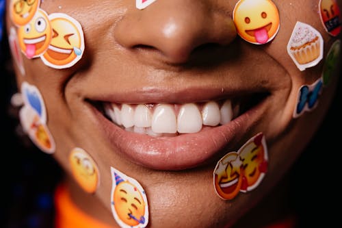 Personne souriante avec des autocollants d'émojis sur le visage