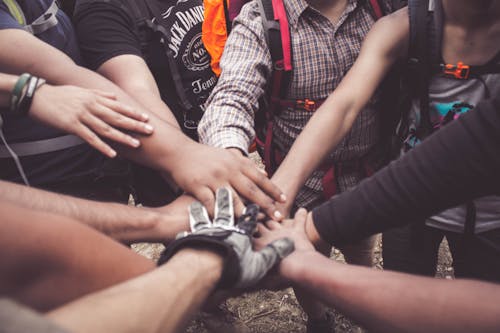 Groupe de personne se regroupant pour se toucher les mains tous ensemble