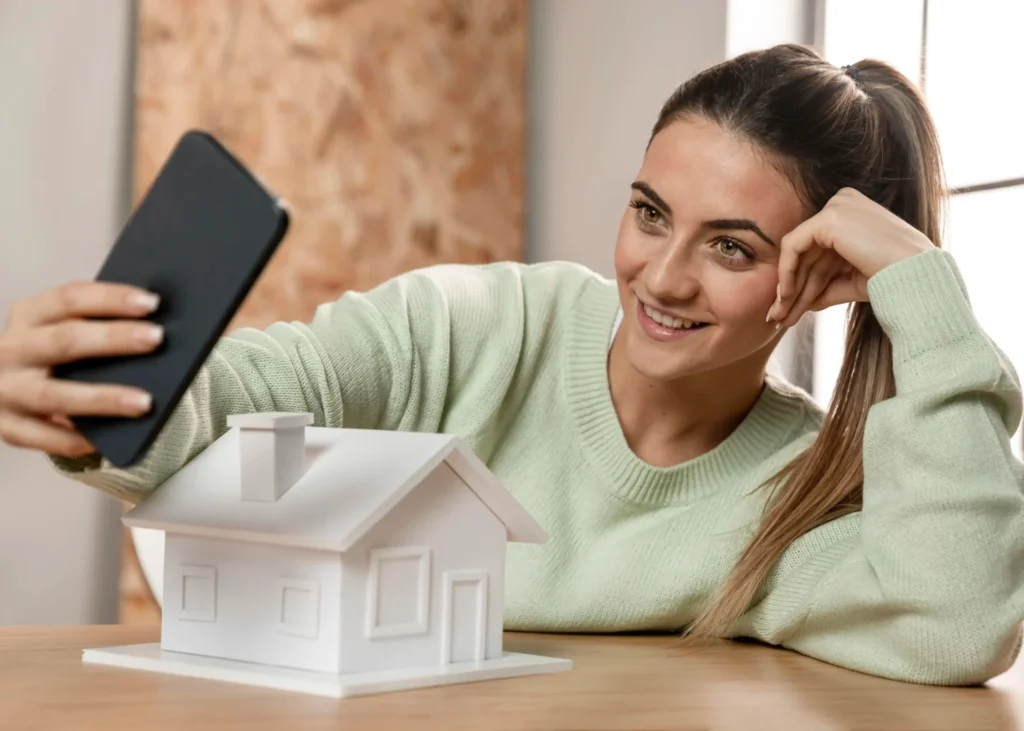 Influenceur immobilier devant une maquete d'une maison