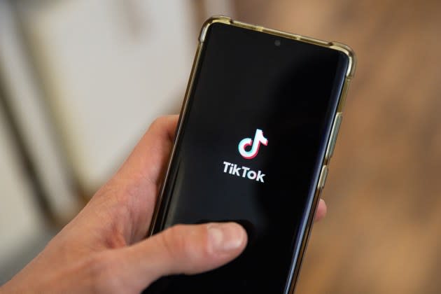 Un homme utilisant l'application TikTok et scrollant avec son doigt